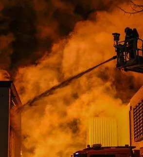 Brandweer bestrijdt een uitslaande brand aan een bedrijfsgebouw